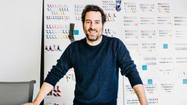 Bombas co-founder Randy Goldberg stands in front of a wall with prototypes of socks