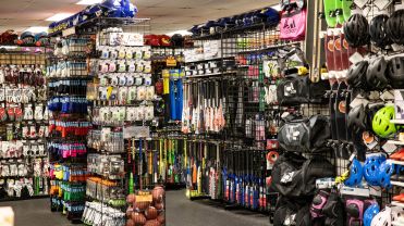 An aisle of helmets, bats and sports gear in a store