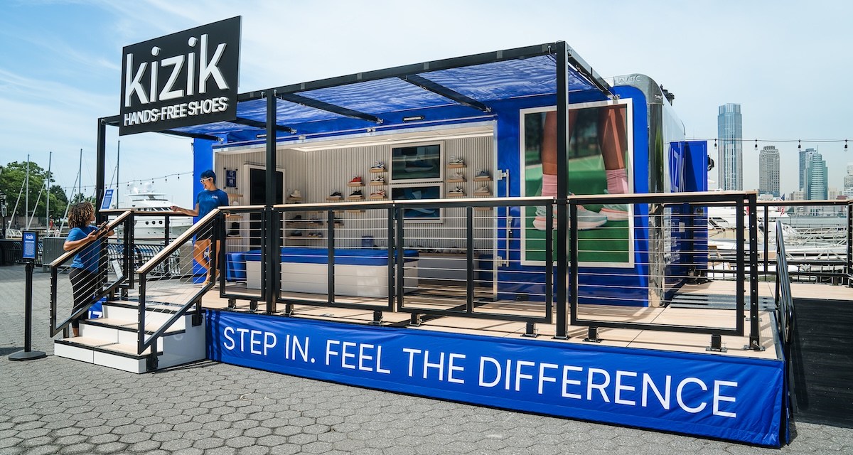 A blue Kizik trailer showing racks of shoes